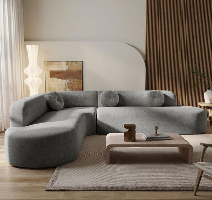 Gray sectional sofa in a modern living room with a coffee table and decorative items.