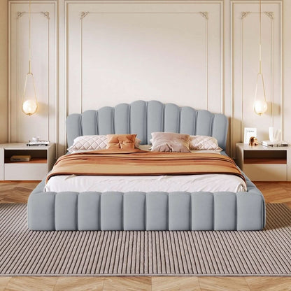 Gray upholstered bed with decorative pillows and a striped blanket in a bedroom setting.