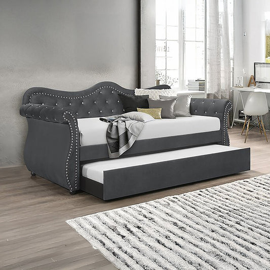 Gray upholstered daybed with tufted details in a room with a desk and chair.