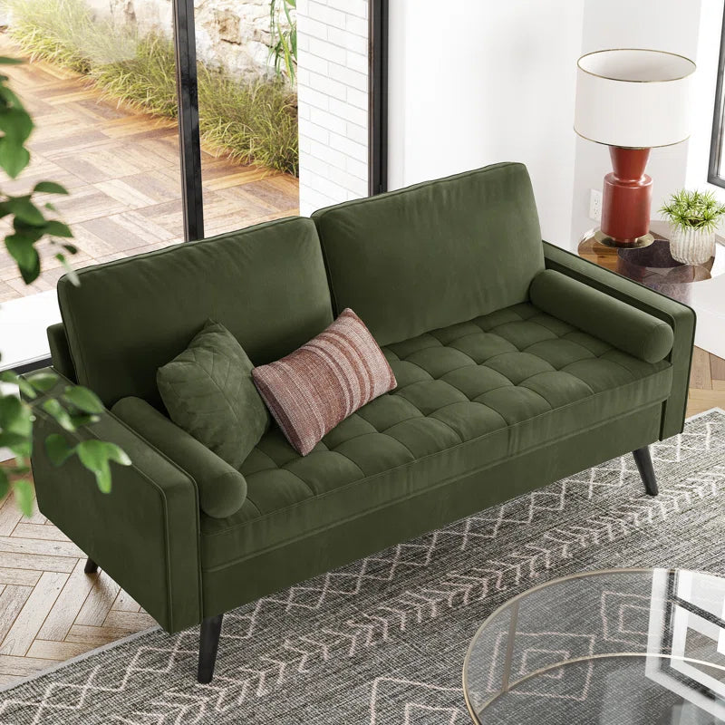 Green sofa with decorative pillows in a living room setting