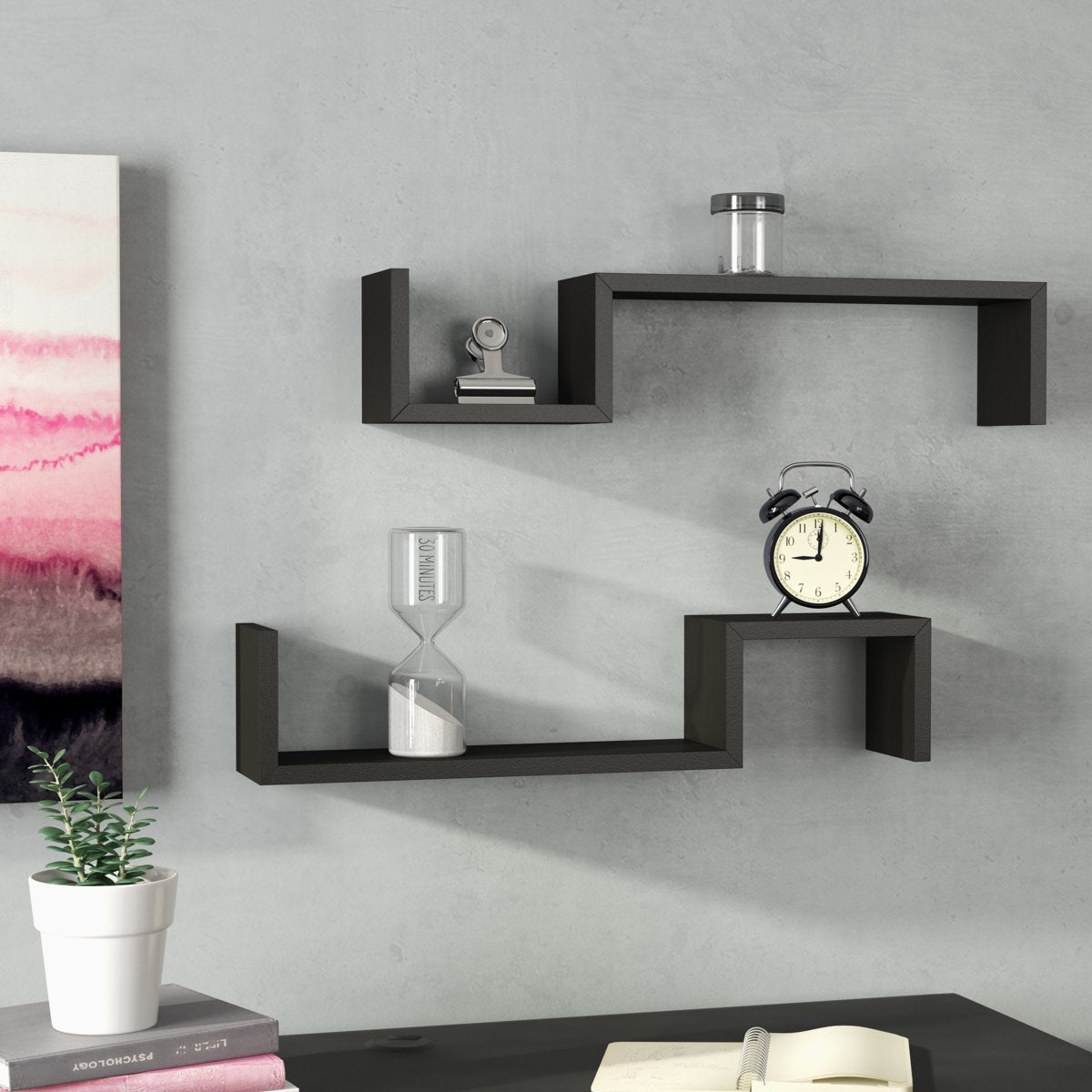Black wall shelves with decorative items on a gray wall