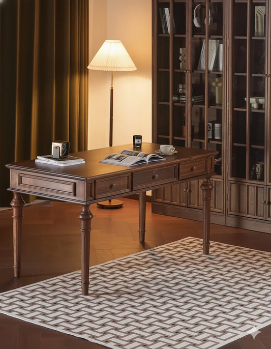 Wooden desk in a room with a lamp and shelves.