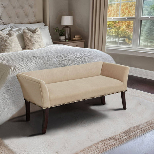 Beige bench in a bedroom setting with a bed and window in the background
