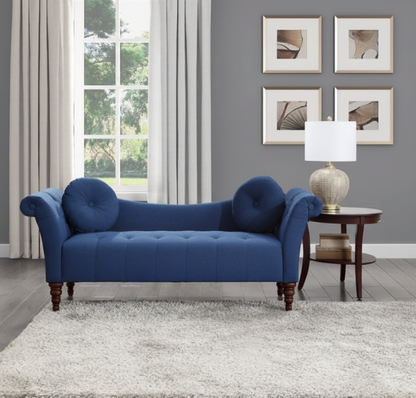 Blue sofa in a living room with gray walls, framed pictures, and a lamp.