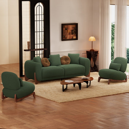 Green sofa and chairs in a living room with wooden floor and large windows.