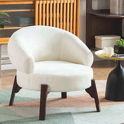 White armchair in a living room setting with a coffee table and decorative items.