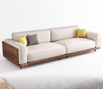 A modern three-seat sofa with cream-colored leather cushions and a dark wood frame, styled with two yellow pillows and one black-and-white checkered pillow on a light gray rug against a white background.