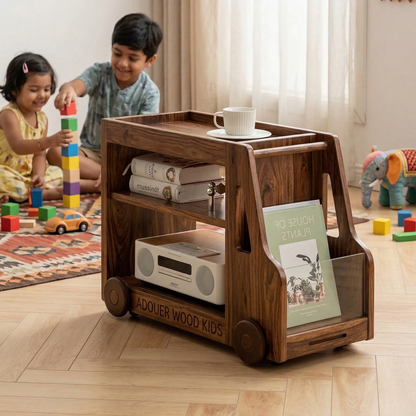 Children playing with a wooden cart in a room filled with toys and books.