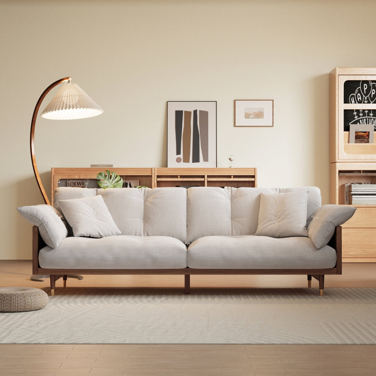 Light gray sofa in a living room with wooden floor and wall decorations