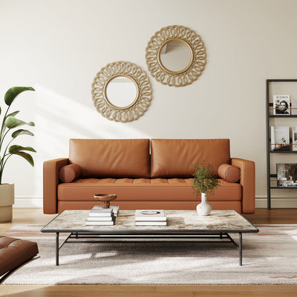 Living room with a brown leather sofa, coffee table, and decorative mirrors.