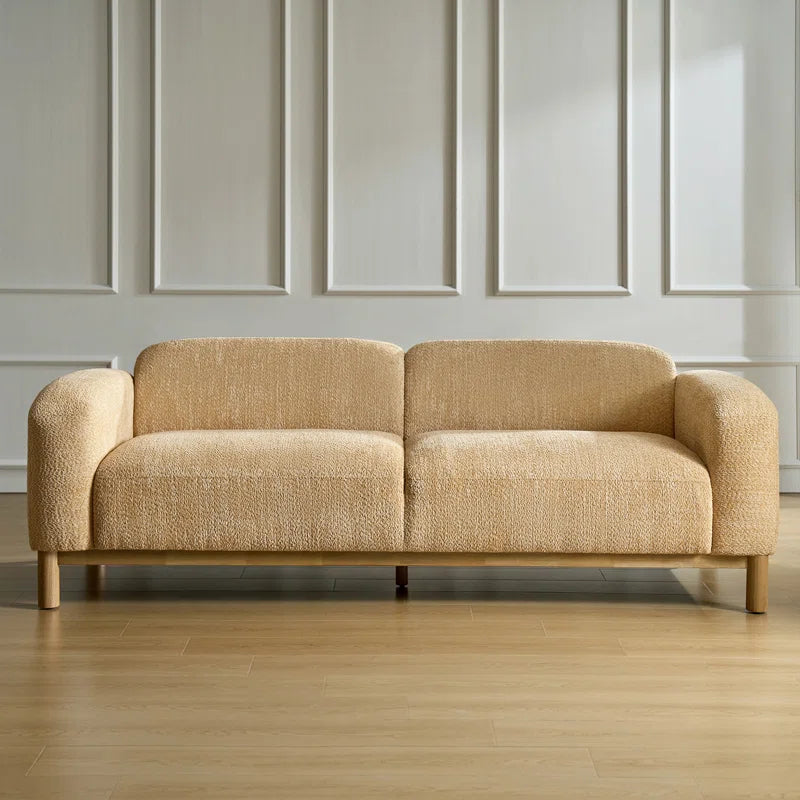 Beige sofa in a room with panelled walls and wooden floor