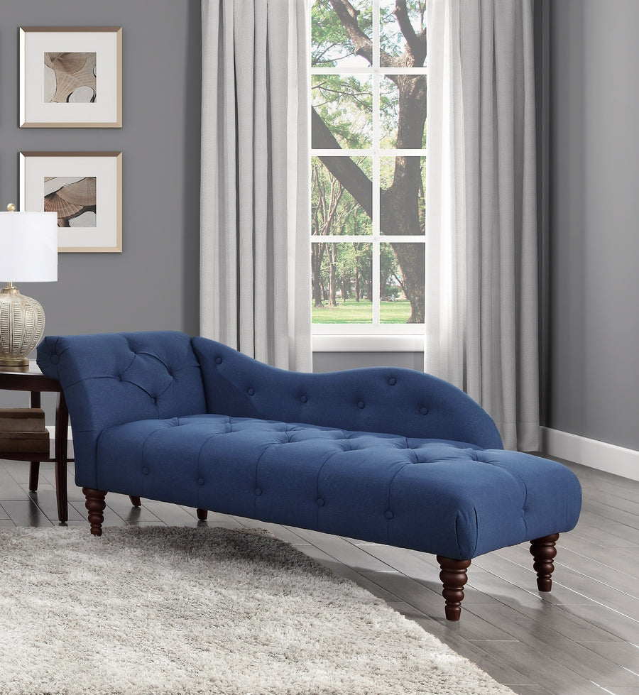Blue tufted chaise lounge in a living room with gray walls and a window.