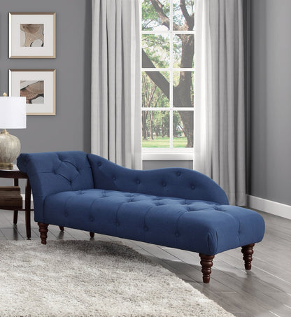 Blue tufted chaise lounge in a living room with gray walls and a window.