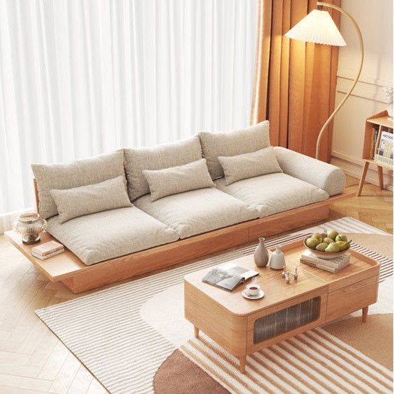 Modern living room with a beige sectional sofa and wooden coffee table.
