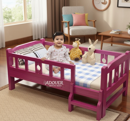 Child sitting on a pink bed with 'ADOUER WOOD  Kids' branding in a room with furniture and decor.
