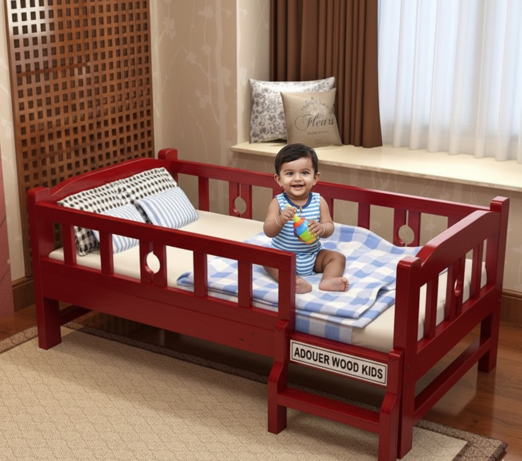 Child playing on a red children's bed with checkered blanket in a room.