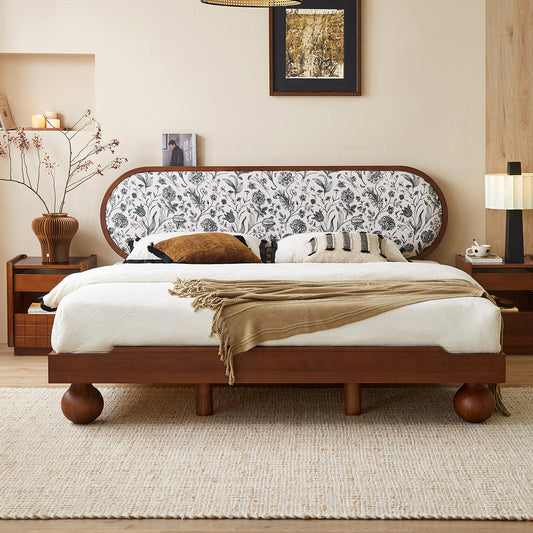 Bedroom with a wooden bed frame featuring a floral headboard, white bedding, and decorative pillows.
