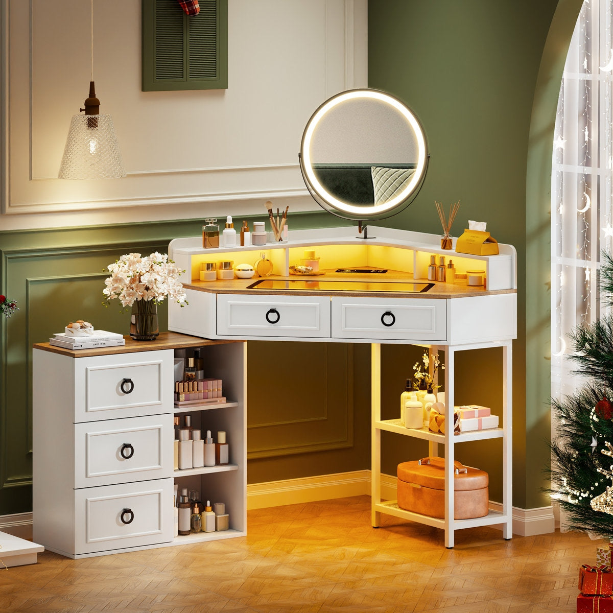 Makeup vanity with round mirror and various items in a room with green walls and a Christmas tree.