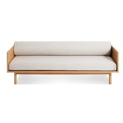 Minimalist wooden sofa with white cushions on a white background