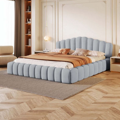 Modern bedroom with a blue upholstered bed and wooden floor.