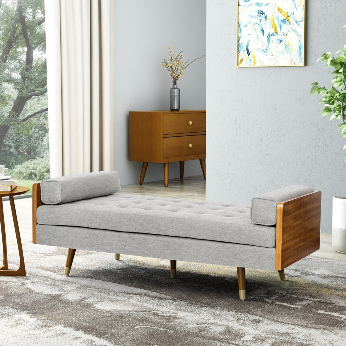 Modern daybed with wooden frame and gray cushion in a room with a painting and plant.