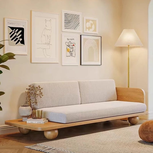 Modern living room with a beige sofa and wooden coffee table, featuring decorative wall art.