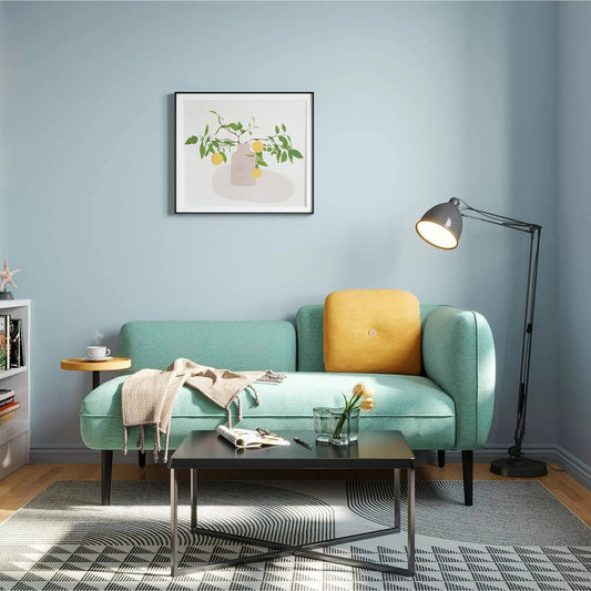 Modern living room with a teal sofa, yellow pillow, and decorative items.