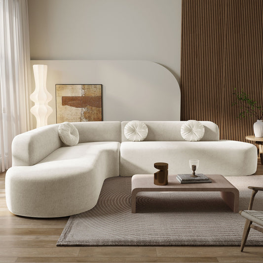 Modern living room with a white sectional sofa, wooden coffee table, and decorative items.