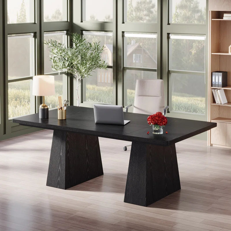 Modern office desk with laptop, lamp, and decor in a bright room with large windows.