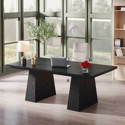Modern office desk with laptop, lamp, and decor in a bright room with large windows.