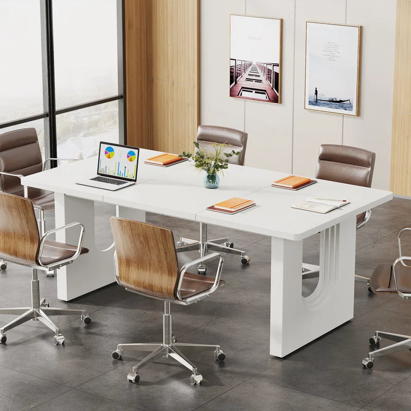 Modern office setup with a white conference table and chairs in a bright room.