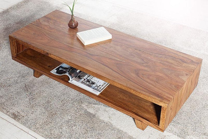 Wooden coffee table with a magazine and decorative items on a light-colored floor.