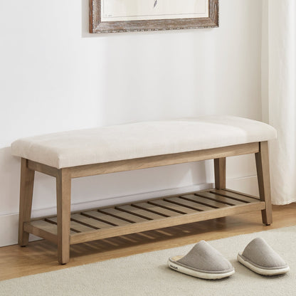 Wooden bench with white cushion on a light wooden floor, with slippers in front.