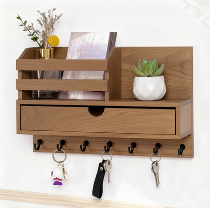 Wooden wall-mounted shelf with a drawer and hooks, holding decorative items.