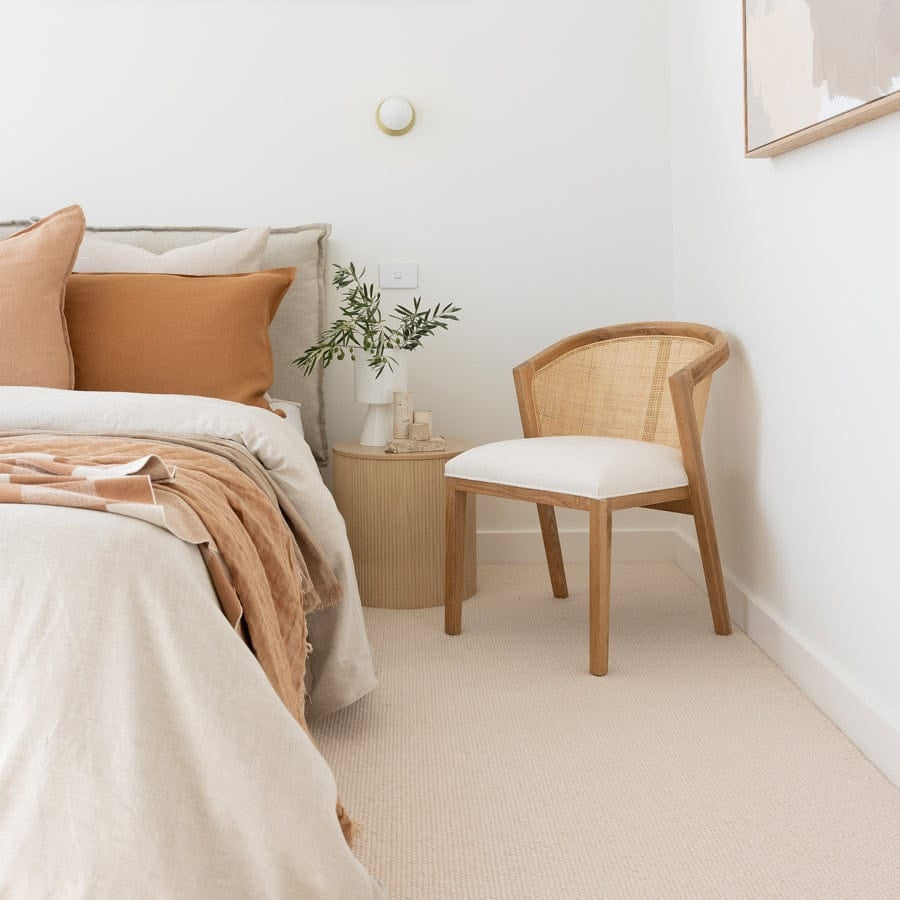 Neatly arranged bedroom with a bed, chair, and small table.