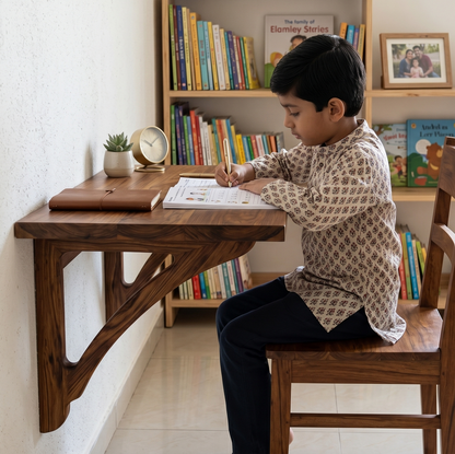 Child sitting at a wooden desk with books and a clock in the background