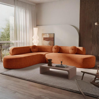 Orange sectional sofa in a modern living room with a coffee table and decorative items.