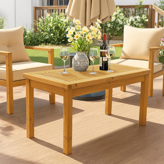 Outdoor patio set with wooden table, chairs, and wine glasses on a sunny day.
