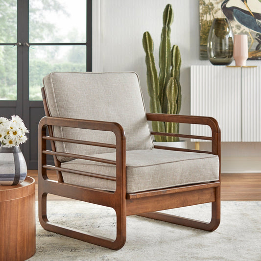 Wooden armchair with beige cushions in a modern living room setting.