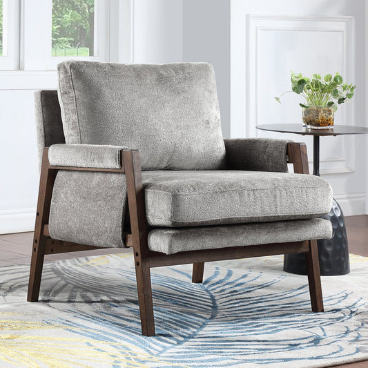 Gray armchair with wooden frame on a patterned rug in a room with a plant and table.