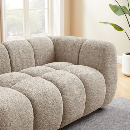 Beige sofa in a living room with a plant and window in the background