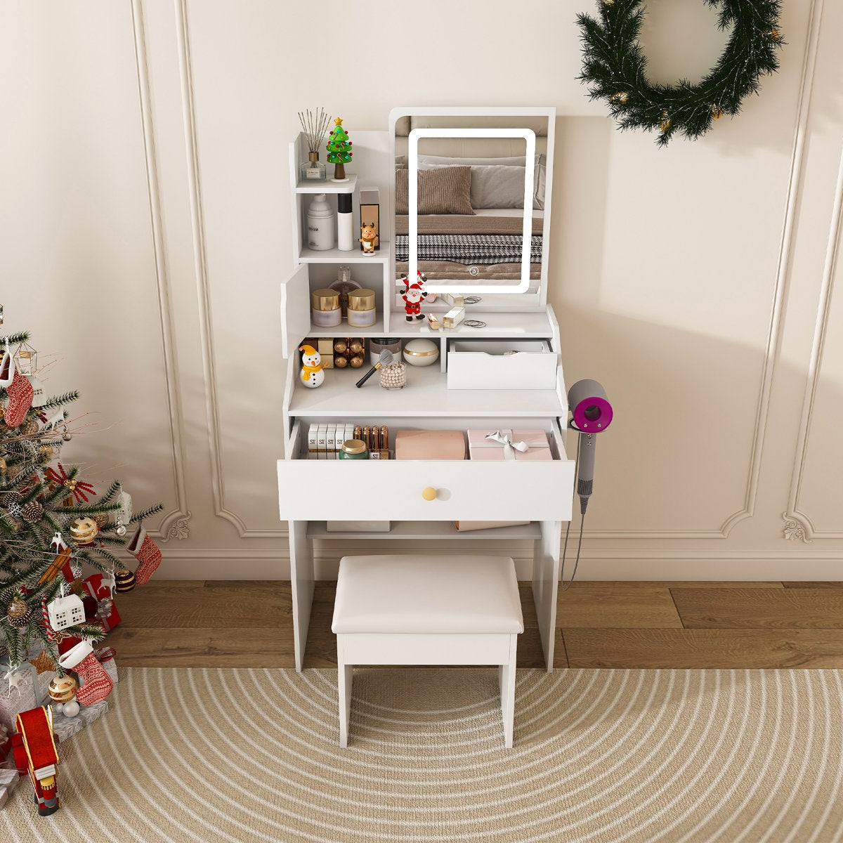 White vanity table with mirror, stool, and decorative items in a room with a Christmas tree and wreath.