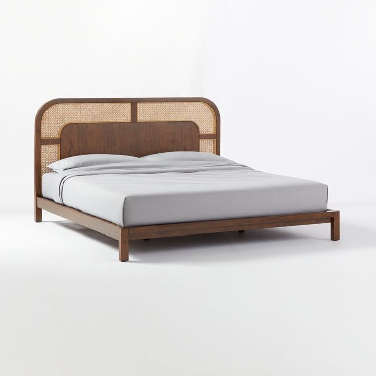 Wooden bed with wicker headboard on a white background