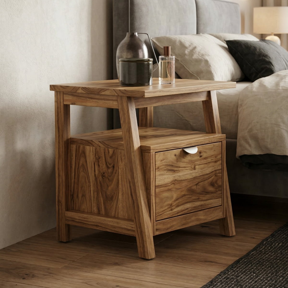 Wooden nightstand with a drawer next to a bed with gray bedding.
