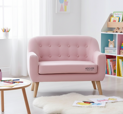 Pink children's sofa with 'ADOUER' branding in a room with books and toys.