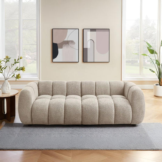 Beige sofa in a living room with abstract art on the wall and plants.