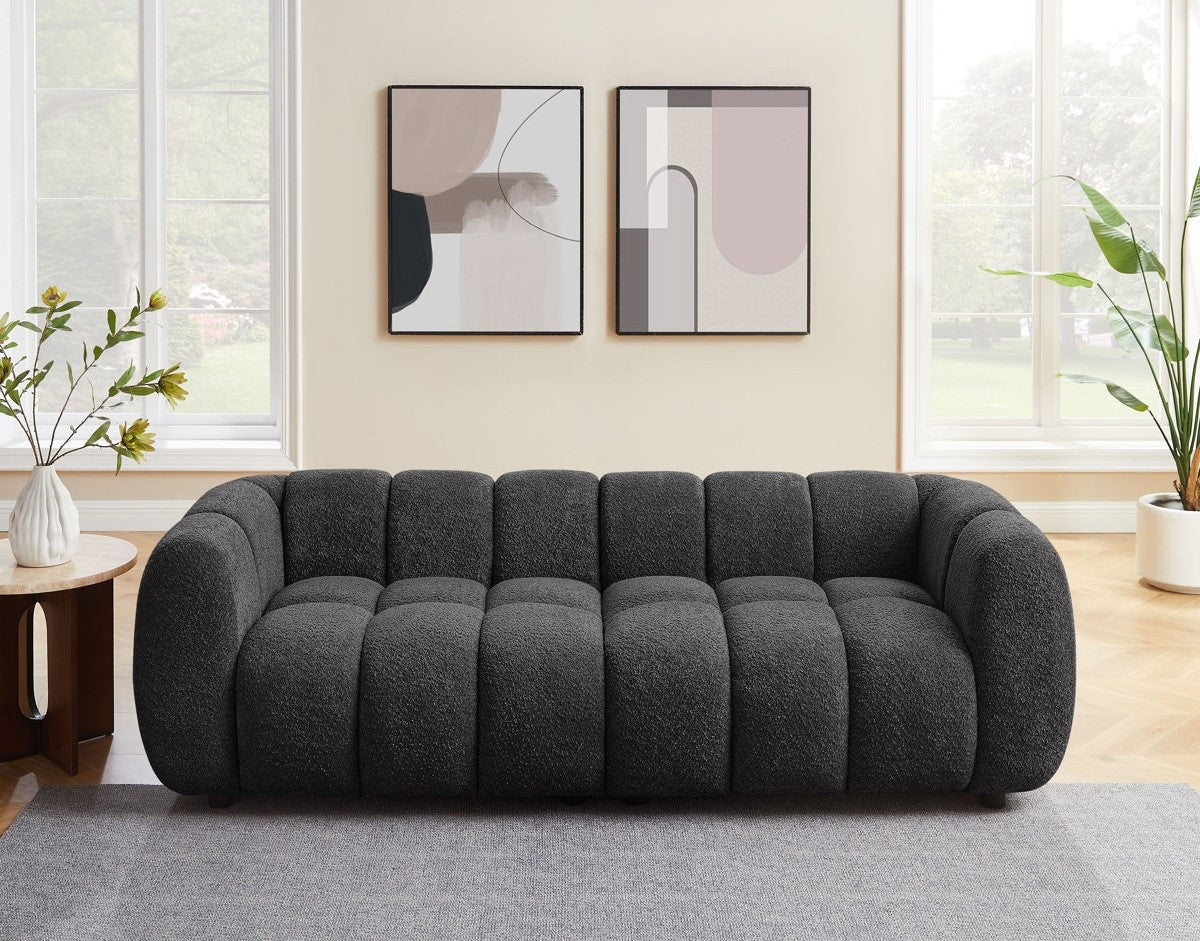Gray sofa in a living room with abstract art on the wall and plants.