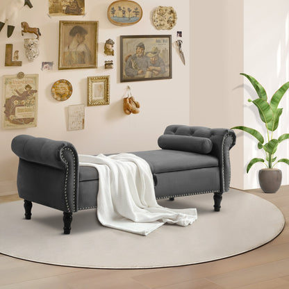 Gray upholstered bench with a white blanket in a room with decorative wall art and a plant.