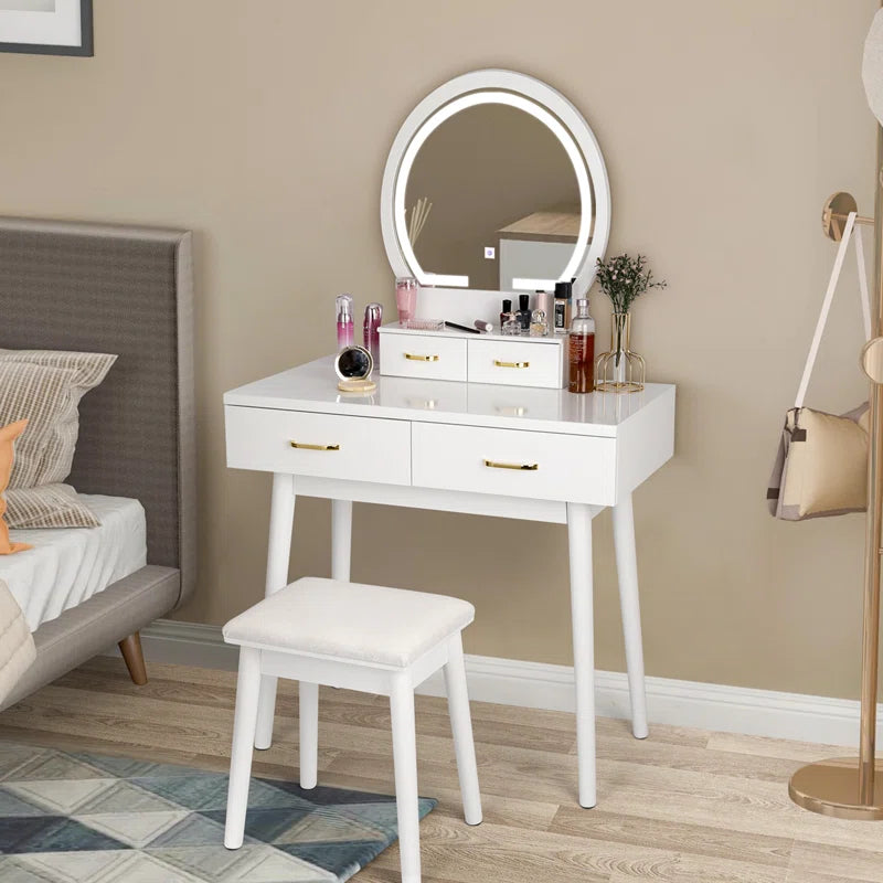 Modern white vanity dressing table with LED mirror and gold handles, featuring four drawers and a stool in a bedroom setting.