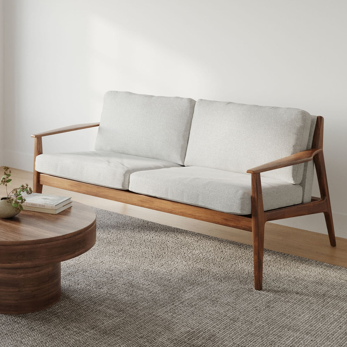 Wooden sofa with white cushions in a minimalistic room.